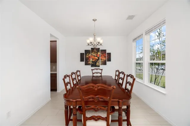 a dining room with furniture a chandelier and window
