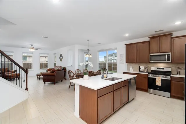 a kitchen with sink a stove and cabinets