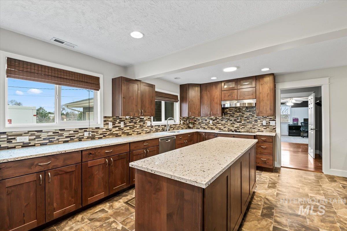 11545 Kuna Road Kuna, ID 83634 - Photo 13 of 50 Kitchen featuring light quartz counters, stone finish flooring, a center island with microwave, recessed lighting, and stainless steel dishwasher, double oven and separate stove top and pot filler