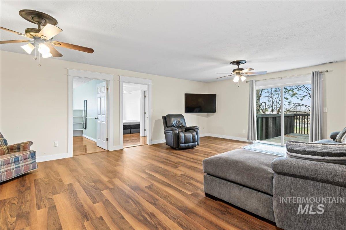 11545 Kuna Road Kuna, ID 83634 - Photo 20 of 50 Living area featuring ceiling fan, wood finished floors, and a textured ceiling