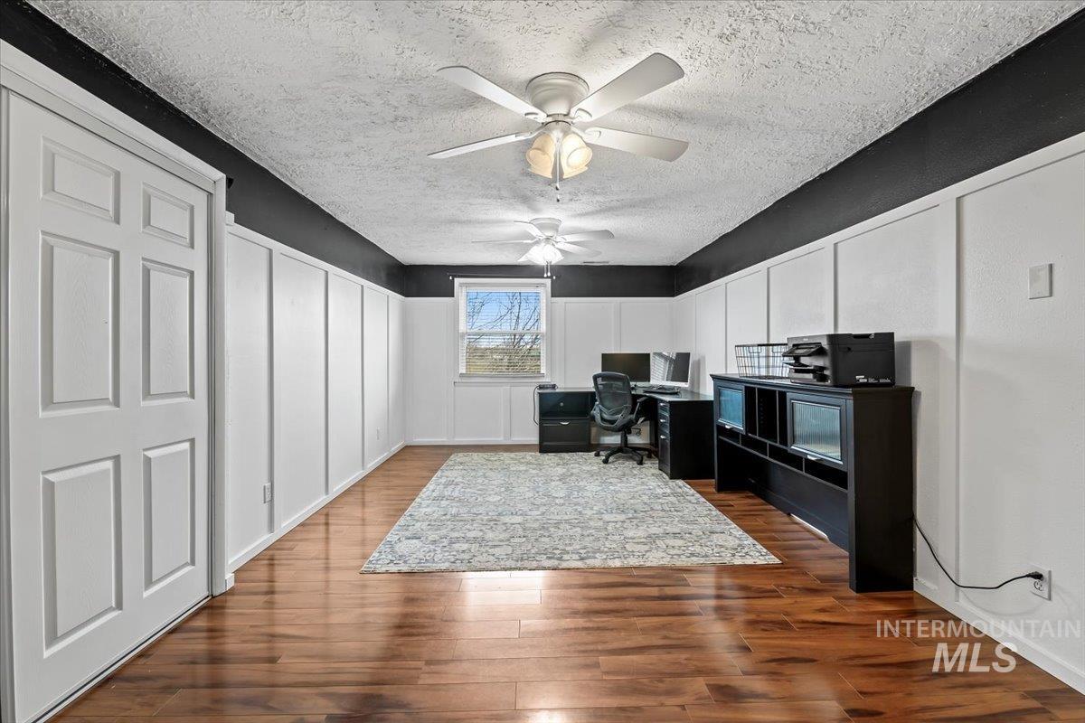 11545 Kuna Road Kuna, ID 83634 - Photo 24 of 50 Office with a decorative wall, dark wood-style flooring, a textured ceiling, and a ceiling fan, or bedroom