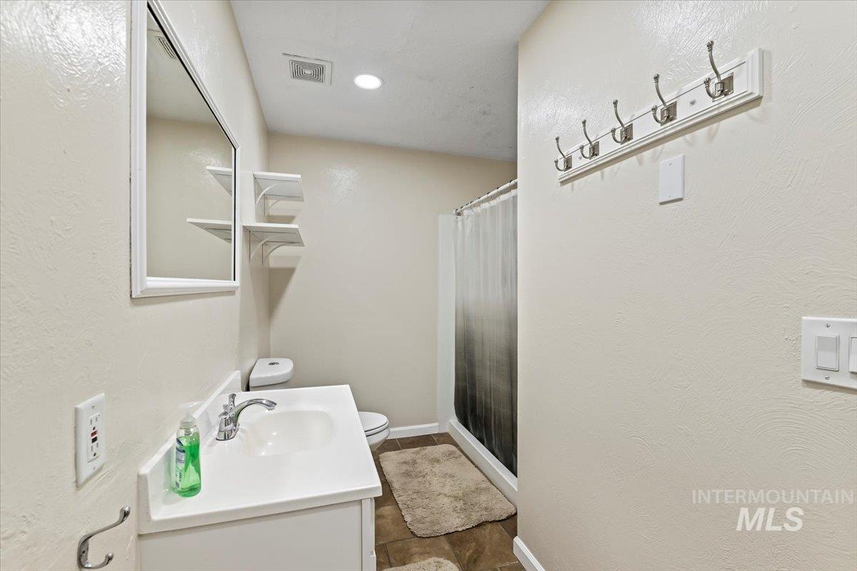 11545 Kuna Road Kuna, ID 83634 - Photo 31 of 50 Full bathroom featuring vanity, a stall shower, and a textured wall