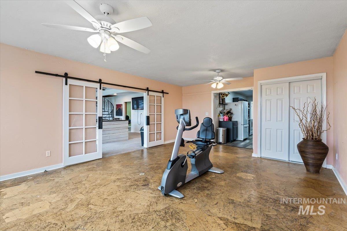 11545 Kuna Road Kuna, ID 83634 - Photo 35 of 50 Can be Bedroom / Exercise / Rec room featuring a barn door and ceiling fan