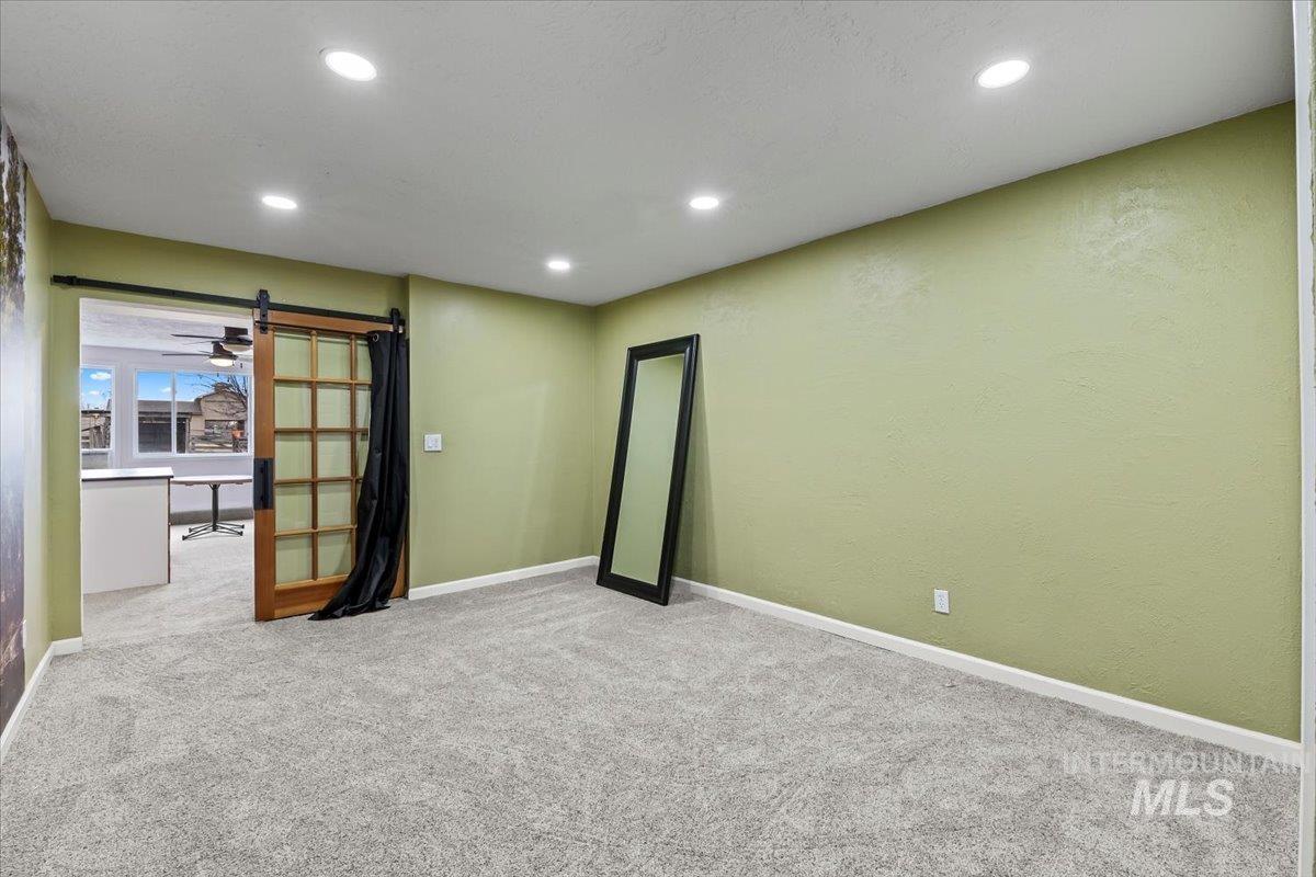 11545 Kuna Road Kuna, ID 83634 - Photo 36 of 50 Spare room with recessed lighting, light carpet, and a barn door