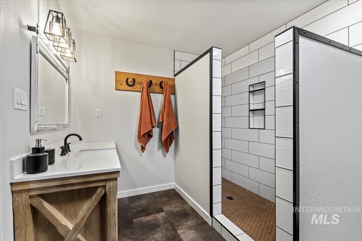 11545 Kuna Road Kuna, ID 83634 - Photo 10 of 50 Full bath with vanity, a walk in shower, and stone finish flooring