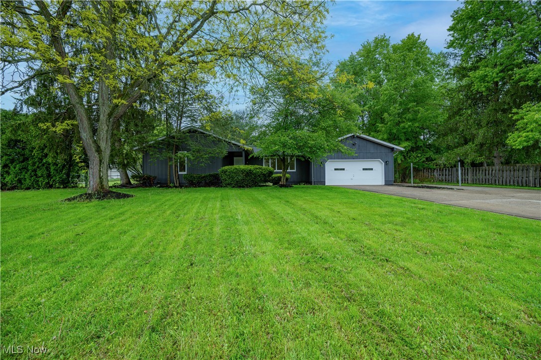 View of front facade featuring asphalt driveway, a garage, and board and batten siding