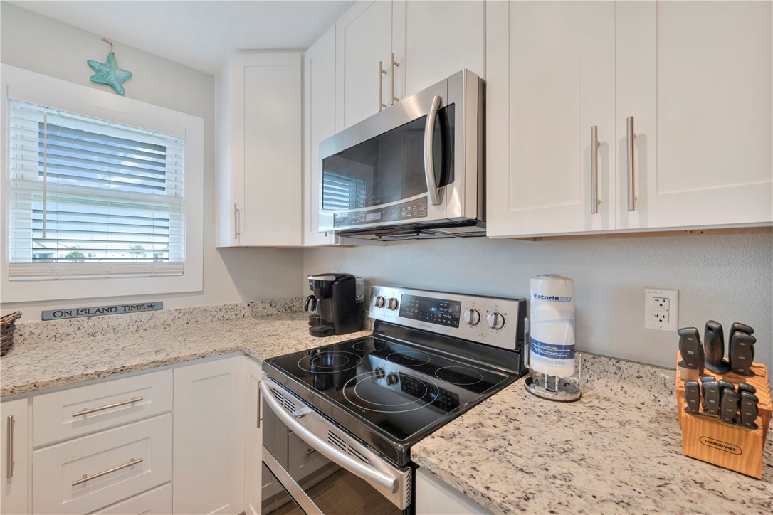 230 Cut-Off Road, Unit 205 Port Aransas, TX 78373 - Photo 11 of 37 a kitchen with stainless steel appliances granite countertop a sink stove and microwave