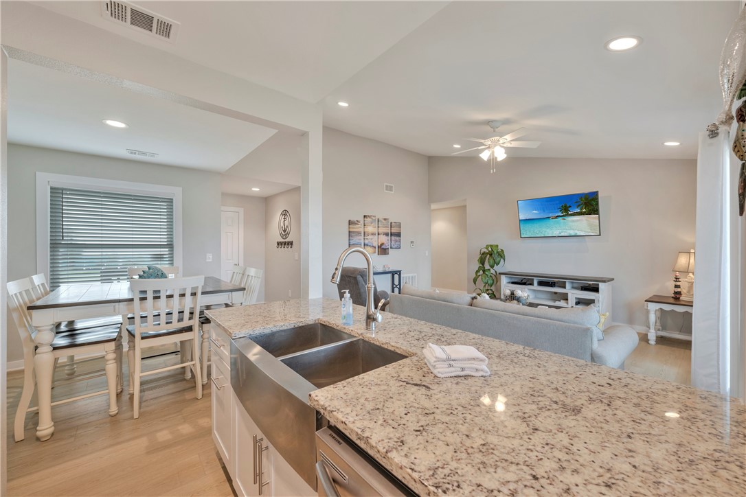 230 Cut-Off Road, Unit 205 Port Aransas, TX 78373 - Photo 12 of 37 a kitchen with stainless steel appliances granite countertop a sink stove and refrigerator