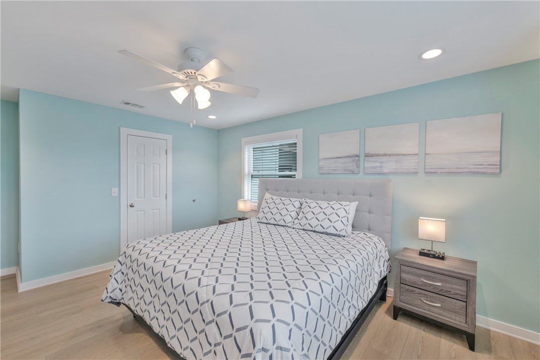 230 Cut-Off Road, Unit 205 Port Aransas, TX 78373 - Photo 20 of 37 a bedroom with a bed and a chandelier