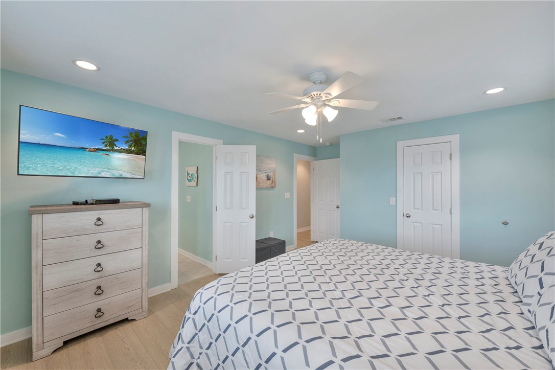 230 Cut-Off Road, Unit 205 Port Aransas, TX 78373 - Photo 22 of 37 a bedroom with a bed and a chandelier
