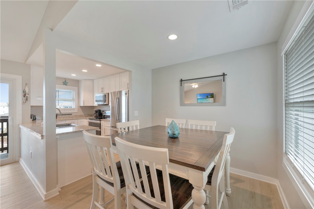 230 Cut-Off Road, Unit 205 Port Aransas, TX 78373 - Photo 5 of 37 a view of a dining room with furniture and a floor to ceiling window