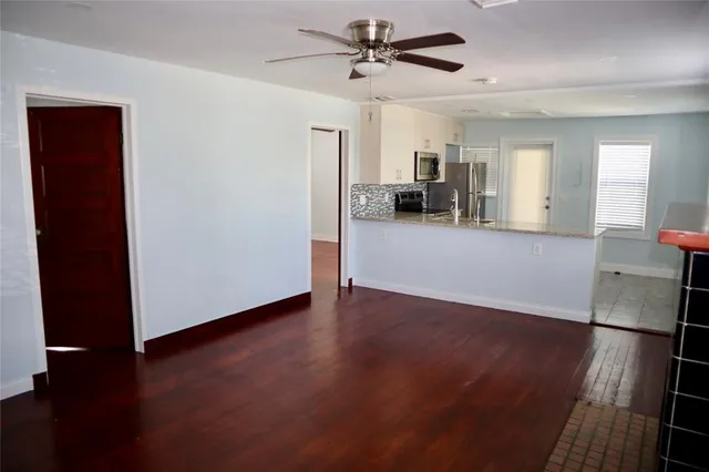 a view of a livingroom with wooden floor and a ceiling fan