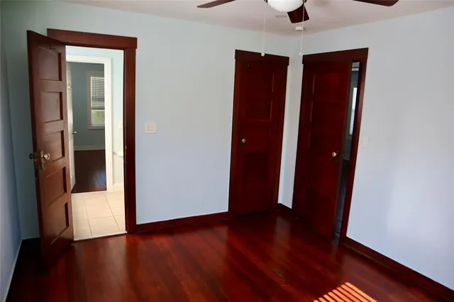 an empty room with wooden floor and closet