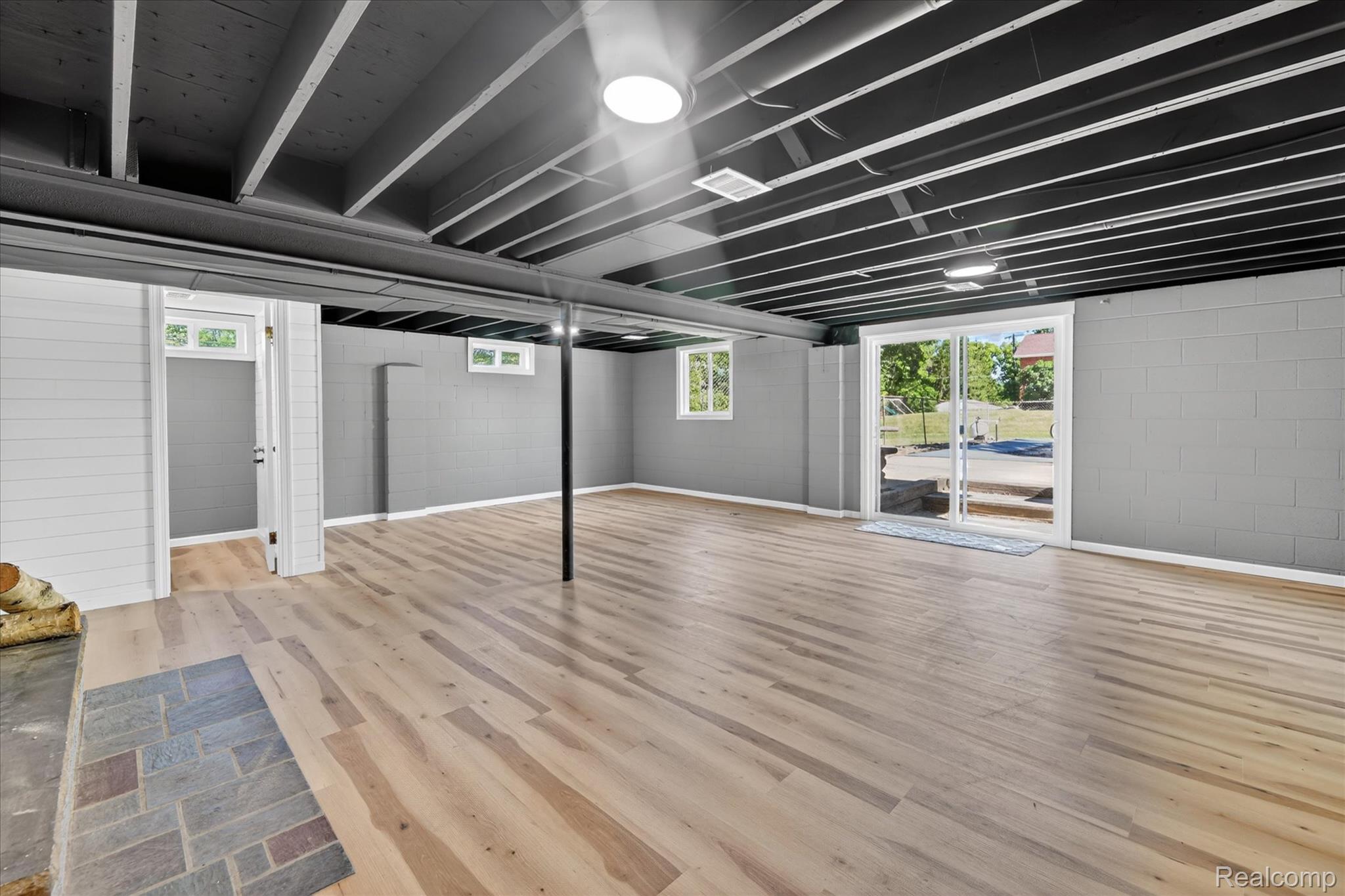 2250 Montague Road Davison, MI 48423 - Photo 33 of 45 Expansive lower-level room featuring light wood-finish flooring, exposed ceiling joists with a dark finish, and recessed lighting