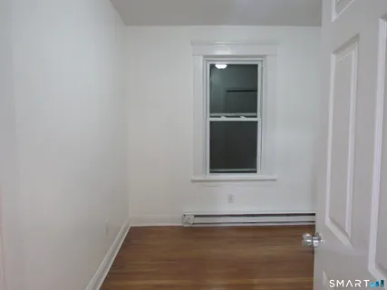 a view of an empty room with cabinet and mirror