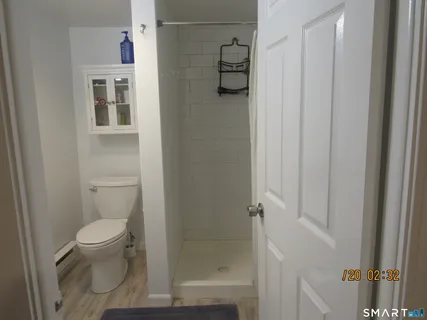 a bathroom with a granite countertop toilet and a shower