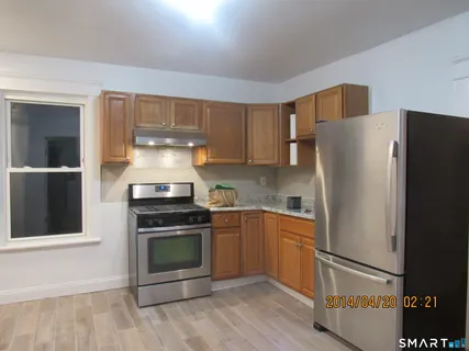 a kitchen with a refrigerator and a stove top oven