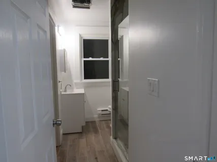 a view of a room with wooden floor and a window