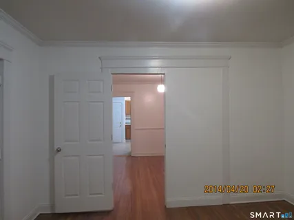 a view of empty room with wooden floor