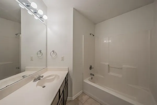 a bathroom with a tub a sink and mirror