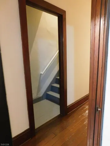 a view of hallway with stairs and wooden floor