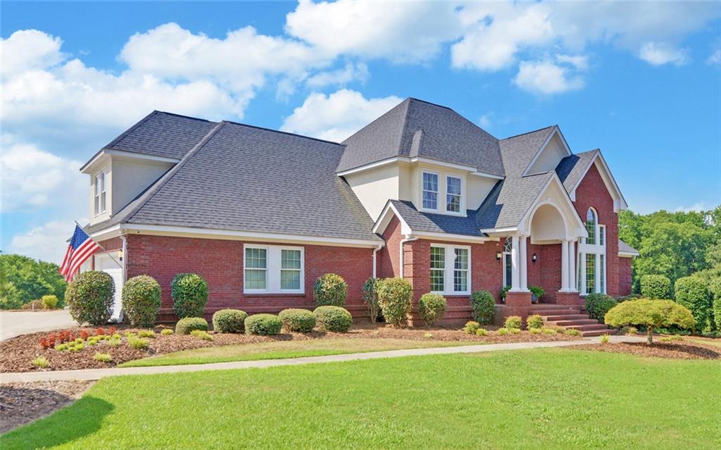 1231 Ednaville Road Braselton, GA 30517 - Photo 1 of 1 a front view of a house with a yard and garage