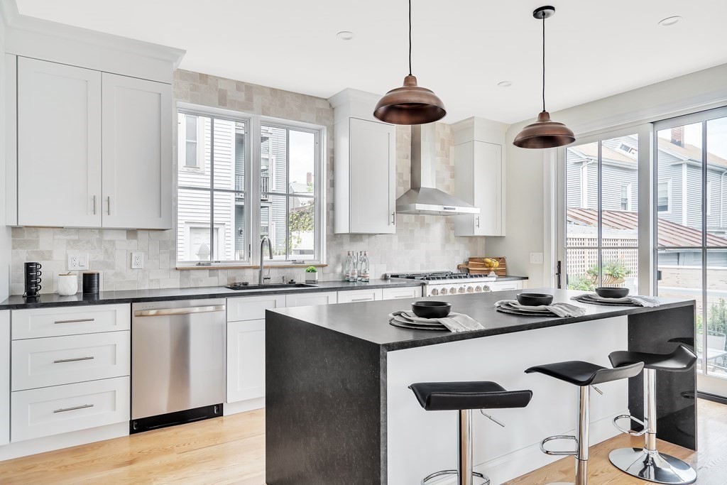 25 Quincy Street, Unit R Somerville, MA 02143 - Photo 6 of 17 a kitchen with stainless steel appliances granite countertop a sink a stove and a window