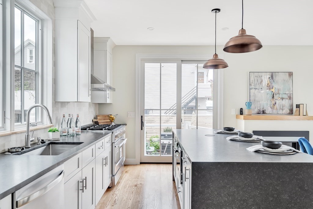 25 Quincy Street, Unit R Somerville, MA 02143 - Photo 7 of 17 a kitchen with stainless steel appliances a sink a stove and a window