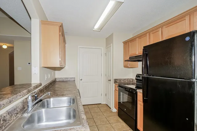 a kitchen with a refrigerator and a sink