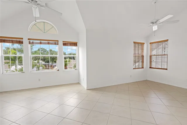 an empty room with windows and ceiling fan