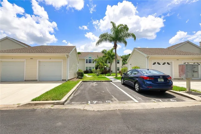 an aerial view of residential houses with outdoor space and trees