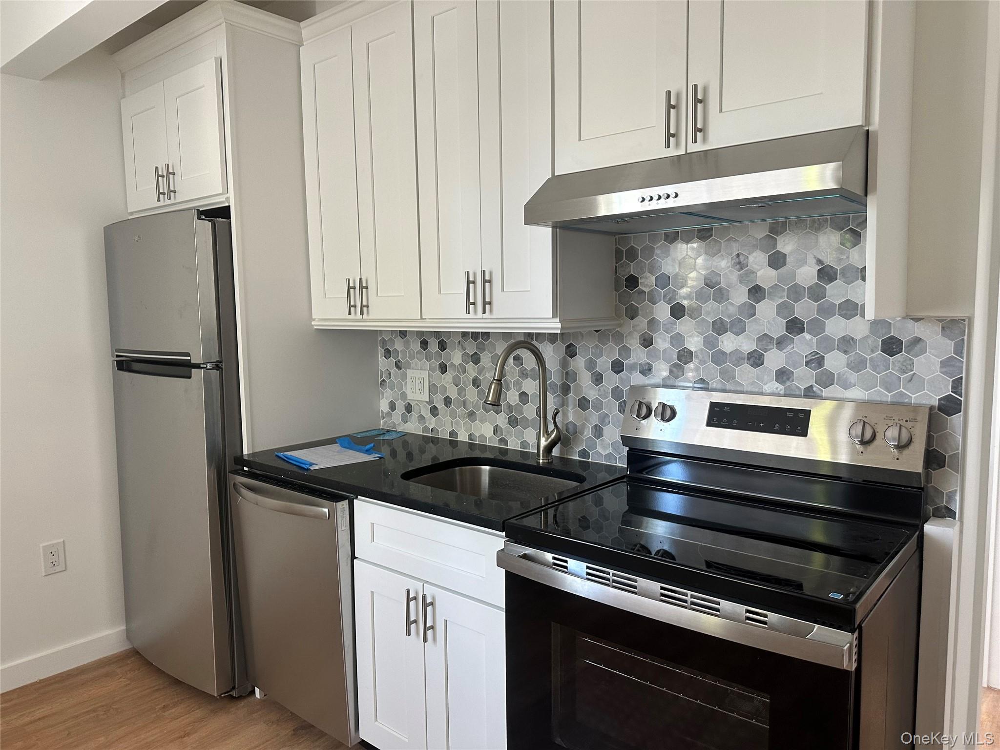 54-01 108th Street, Unit 2F Queens, NY 11368 - Photo 2 of 5 a kitchen with stainless steel appliances granite countertop a stove and a refrigerator