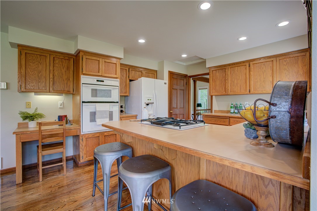 18322 Bellflower Road Bothell, WA 98012 - Photo 15 of 34 a kitchen with a table chairs refrigerator and cabinets