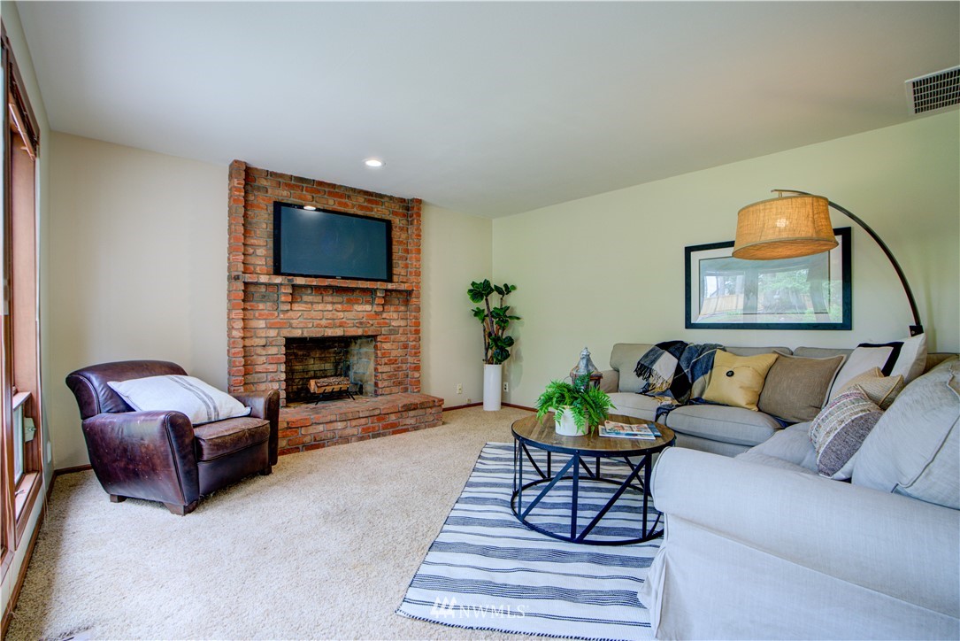 18322 Bellflower Road Bothell, WA 98012 - Photo 21 of 34 a living room with furniture a fireplace and a flat screen tv