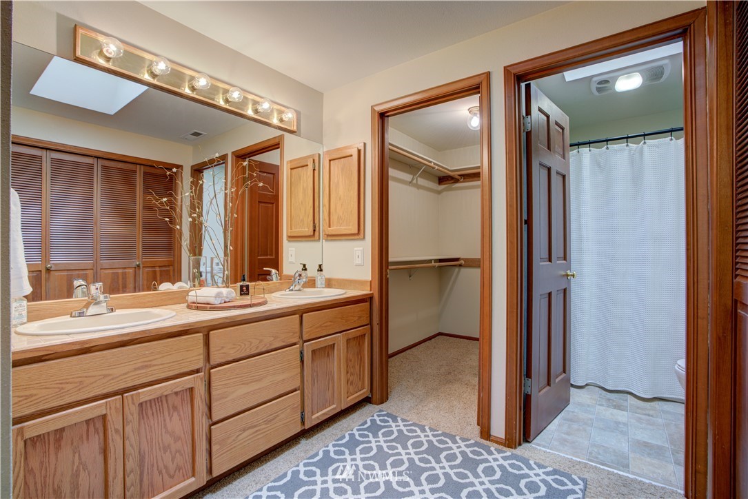 18322 Bellflower Road Bothell, WA 98012 - Photo 29 of 34 a bathroom with a double vanity sink and a mirror