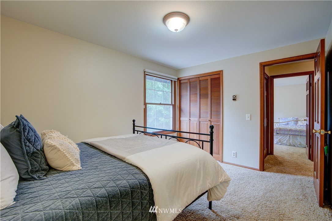18322 Bellflower Road Bothell, WA 98012 - Photo 32 of 34 a bedroom with a bed and a large mirror