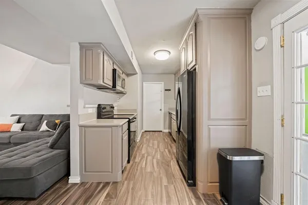 a kitchen with a sink dishwasher a stove and a refrigerator with wooden floor