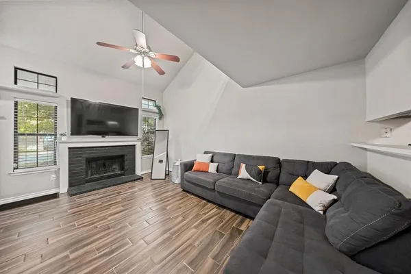 a living room with furniture a fireplace and a flat screen tv