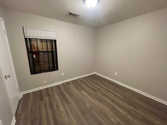 a view of an empty room with wooden floor