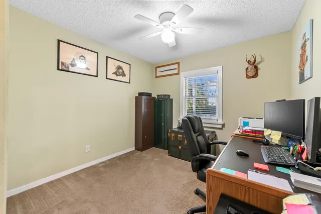 a view of a workspace with furniture and a window