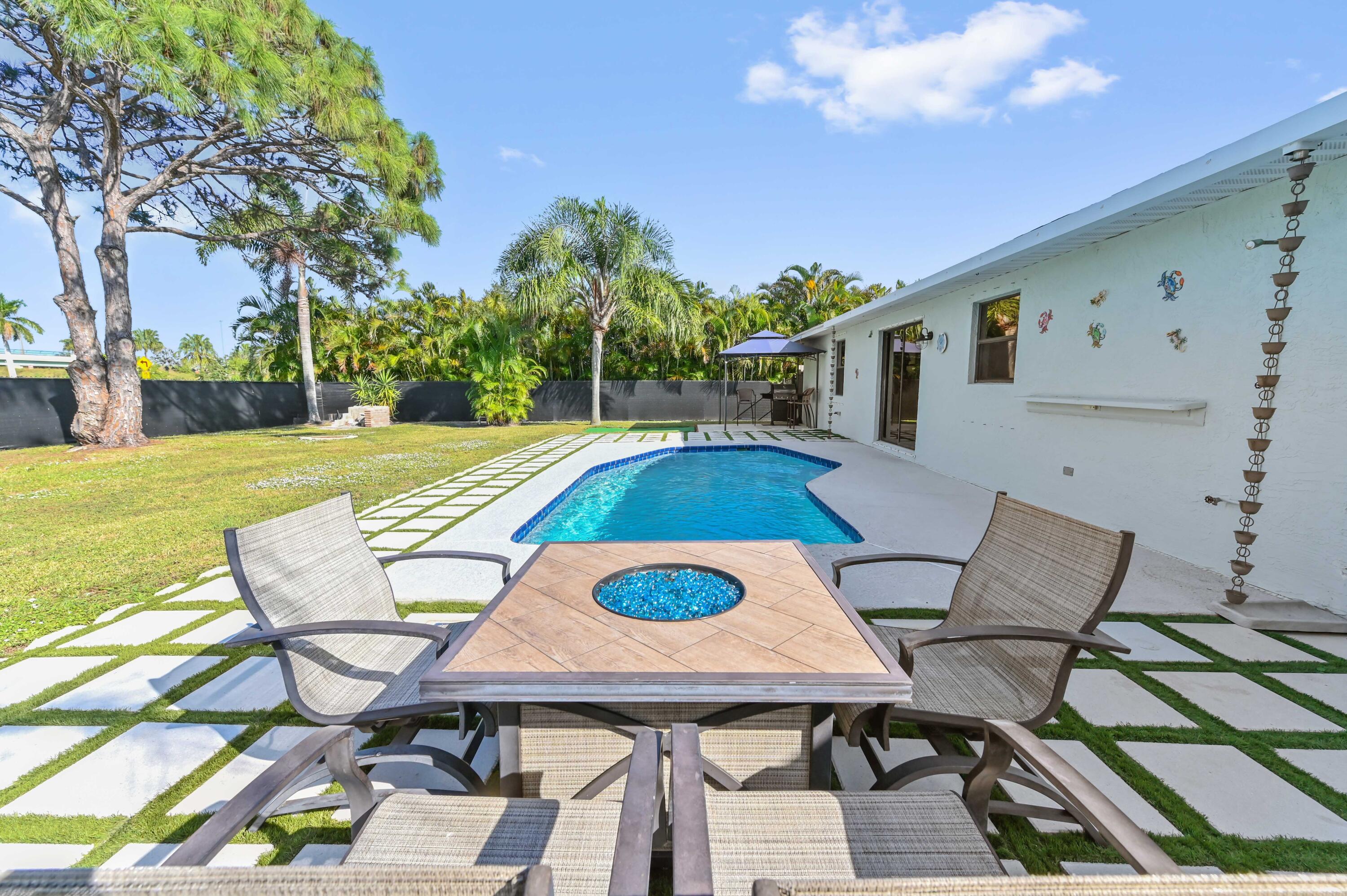 665 Southwest Backert Avenue Port St. Lucie, FL 34953 - Photo 27 of 46 a view of a patio with table and chairs with wooden floor and fence
