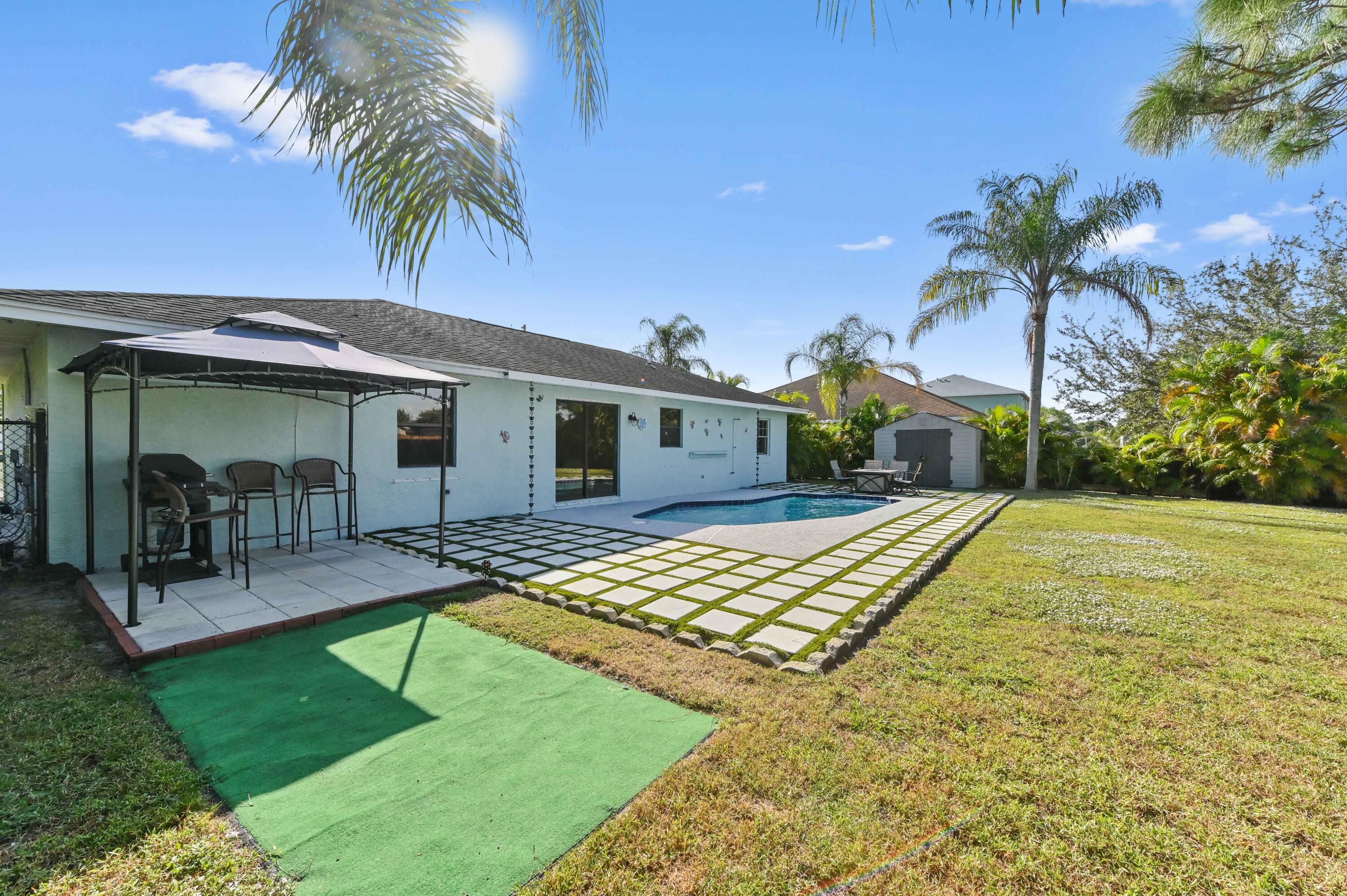 665 Southwest Backert Avenue Port St. Lucie, FL 34953 - Photo 29 of 46 a front view of house with yard and swimming pool