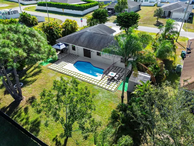 an aerial view of a house with swimming pool and garden