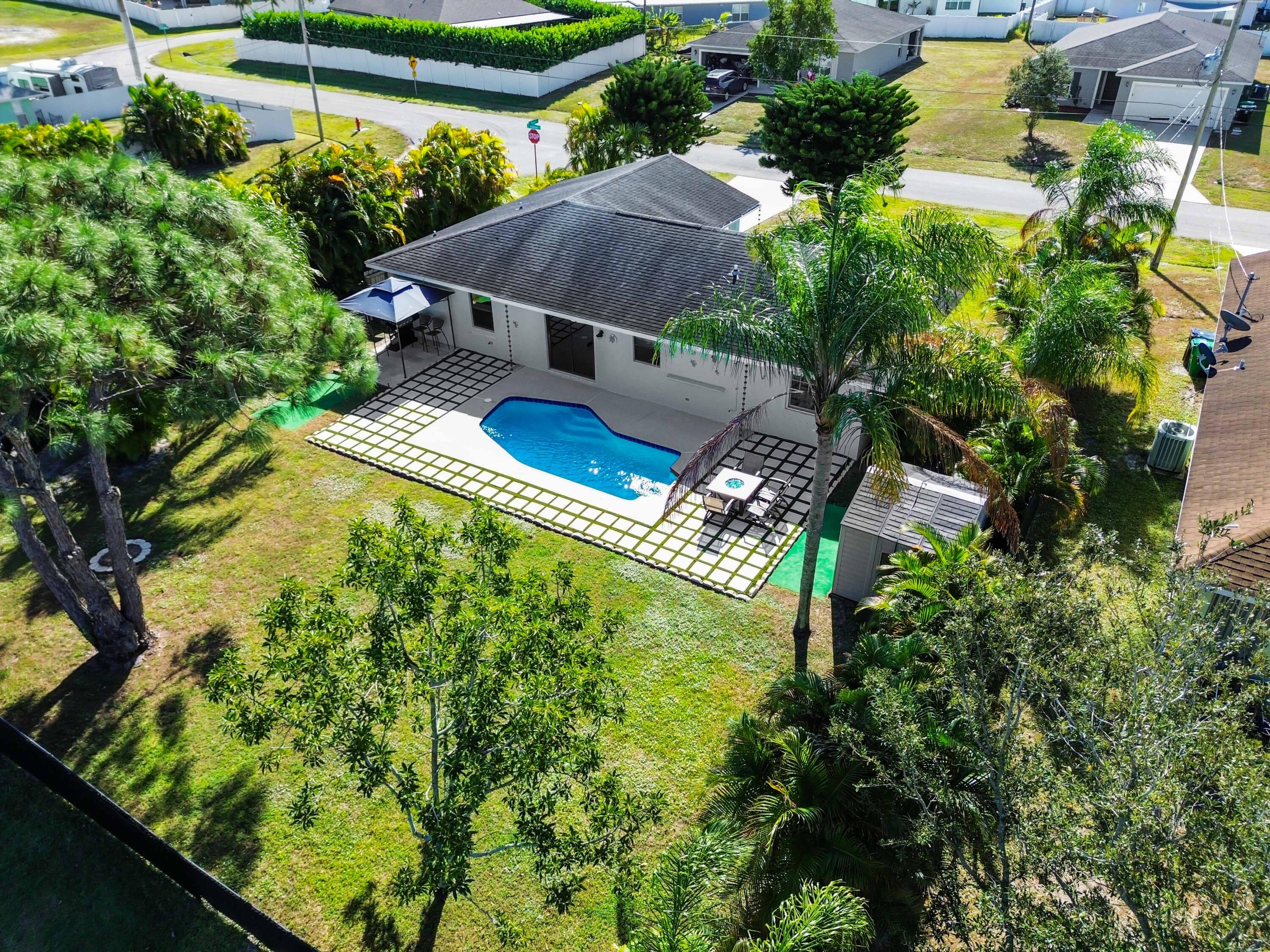 665 Southwest Backert Avenue Port St. Lucie, FL 34953 - Photo 4 of 46 an aerial view of a house with swimming pool and garden