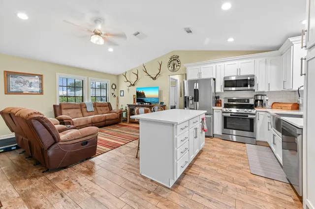 a living room with furniture a flat screen tv and a fireplace