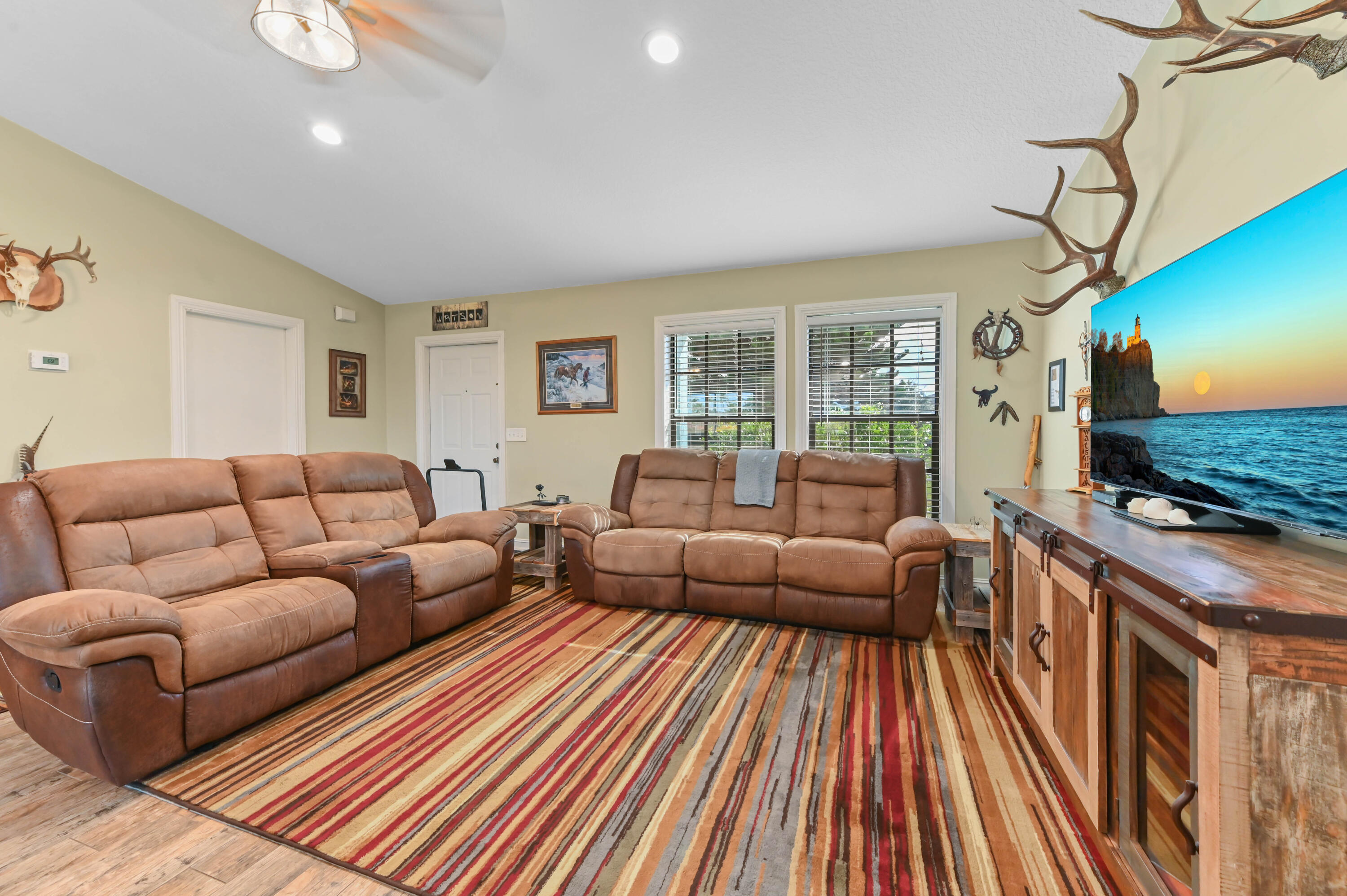 665 Southwest Backert Avenue Port St. Lucie, FL 34953 - Photo 10 of 46 a living room with furniture a flat screen tv and a fireplace