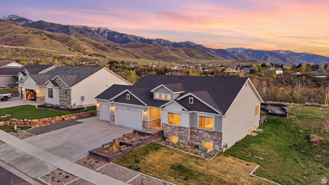 638 Canyon Rim Road Smithfield, UT 84335 - Photo 1 of 56 View of front of house featuring stone siding, driveway, a garage, and a mountain view