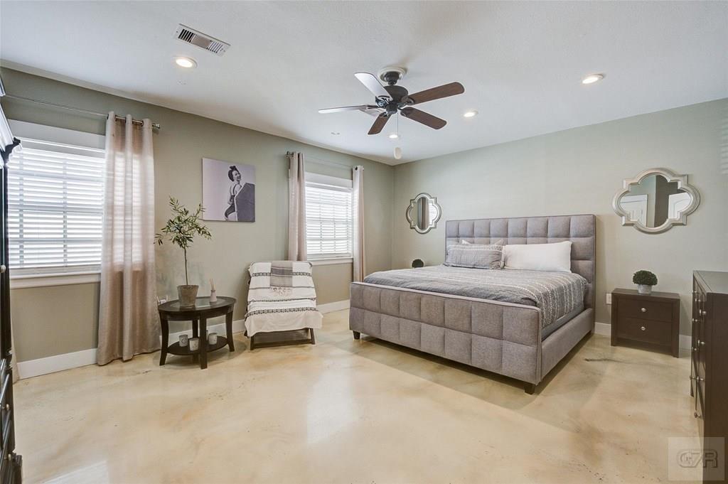 10213 Stewart Road Galveston, TX 77554 - Photo 26 of 49 a bedroom with a bed and a chandelier