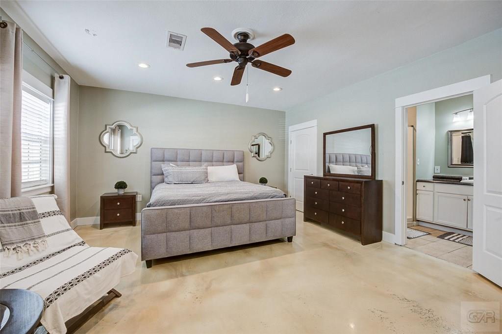 10213 Stewart Road Galveston, TX 77554 - Photo 27 of 49 a bedroom with a large bed and a chandelier