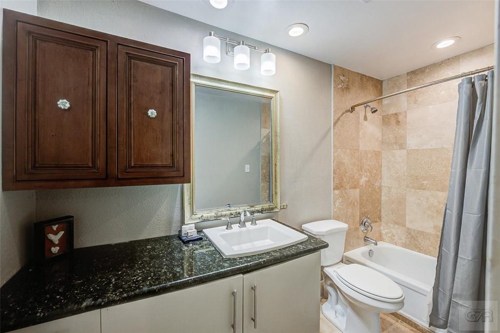 10213 Stewart Road Galveston, TX 77554 - Photo 33 of 49 a bathroom with a granite countertop sink toilet and shower
